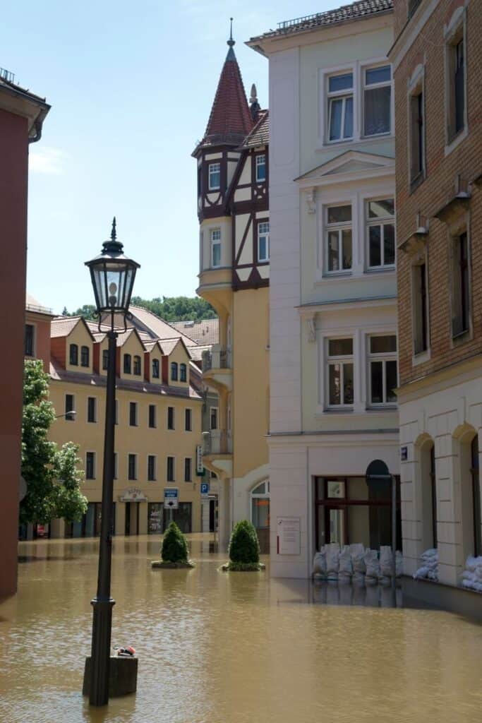 A picturesque European street submerged in floodwaters, highlighting the impact of natural disasters.